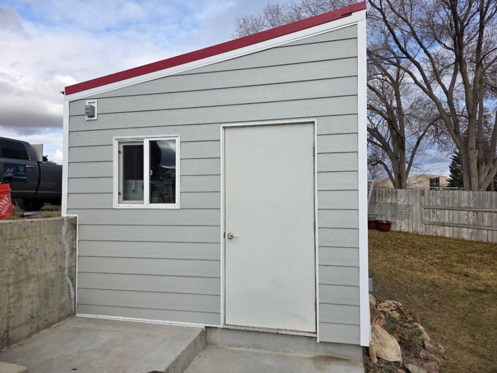 Small gray shed with red roof