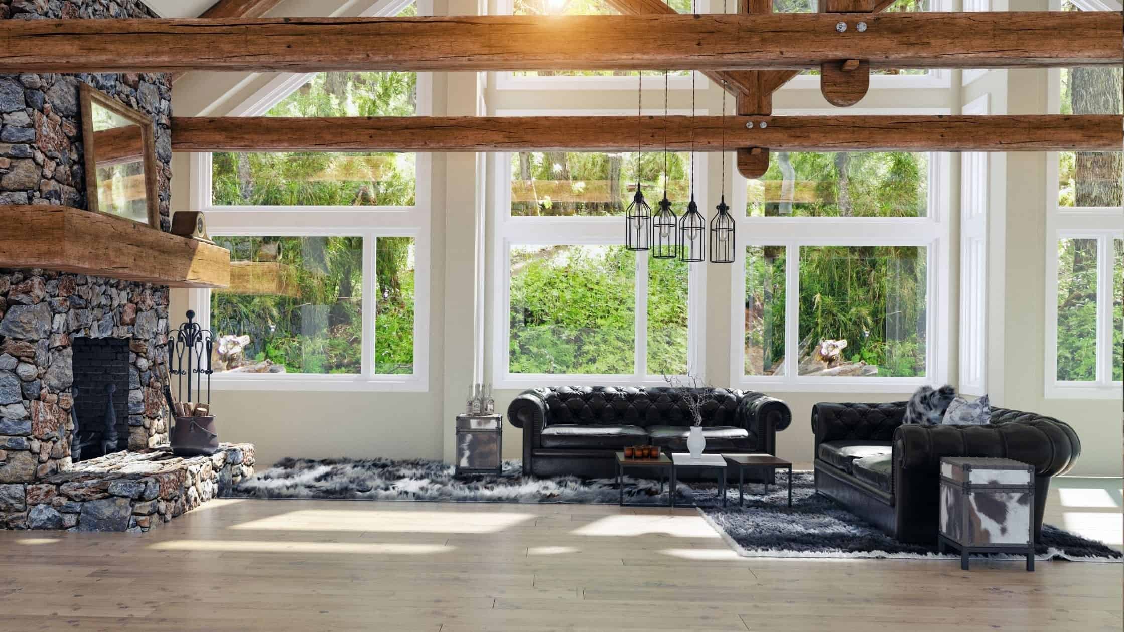 Bright living room with large NTY windows, black leather sofas, and a stone fireplace.