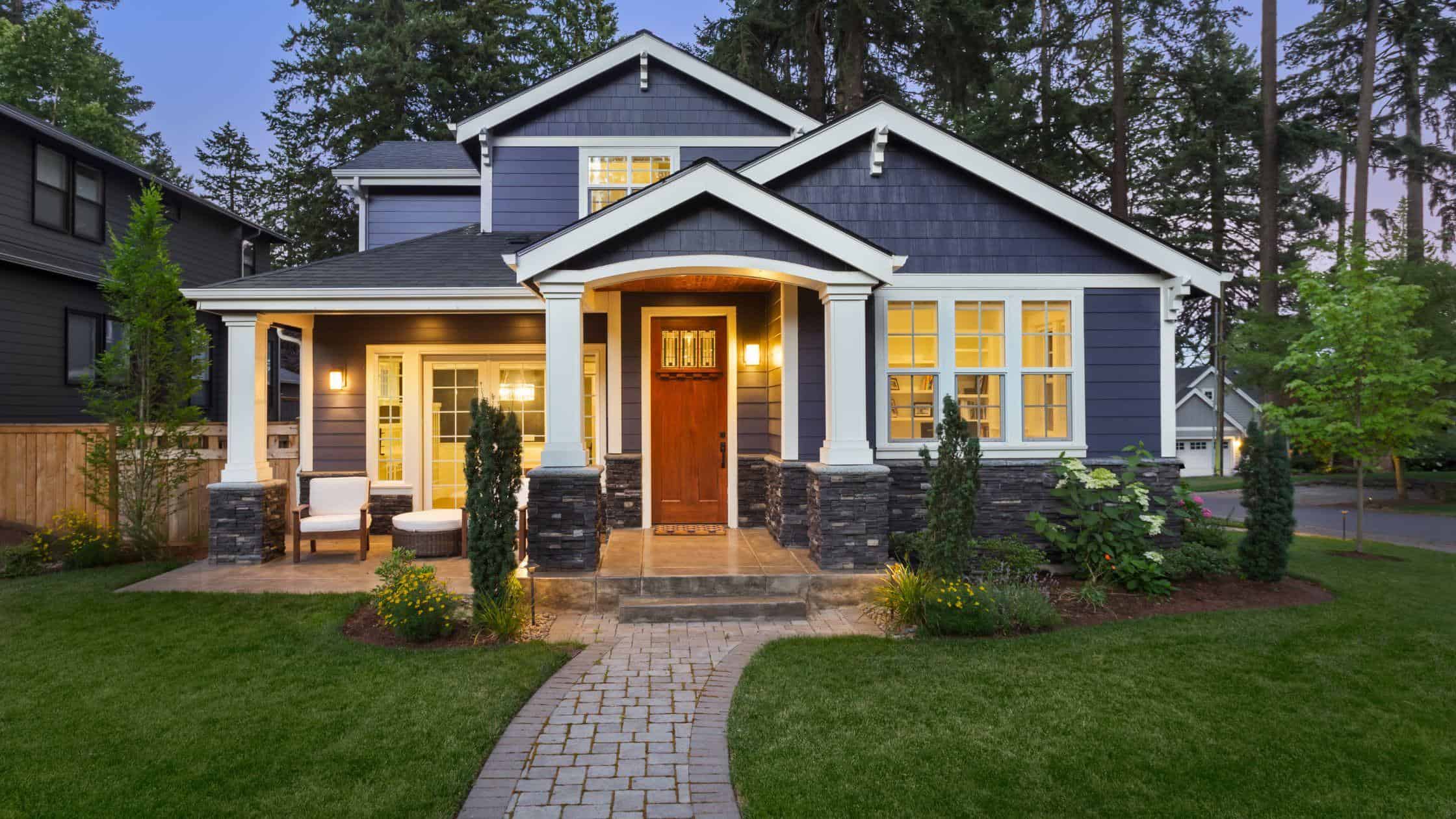 Beautiful blue house with new windows and inviting porch, perfect for home improvement projects.